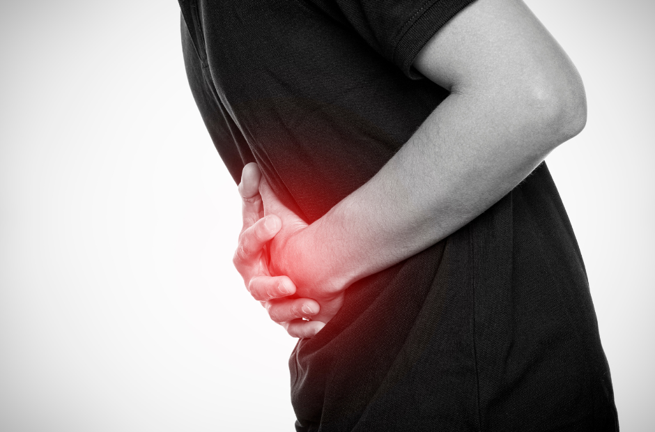 A black and white photo of a man holding his stomach with a red light indicating pain.